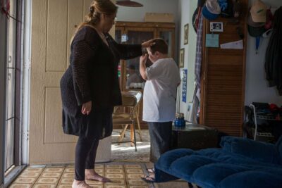 Woman reassures child in doorway.
