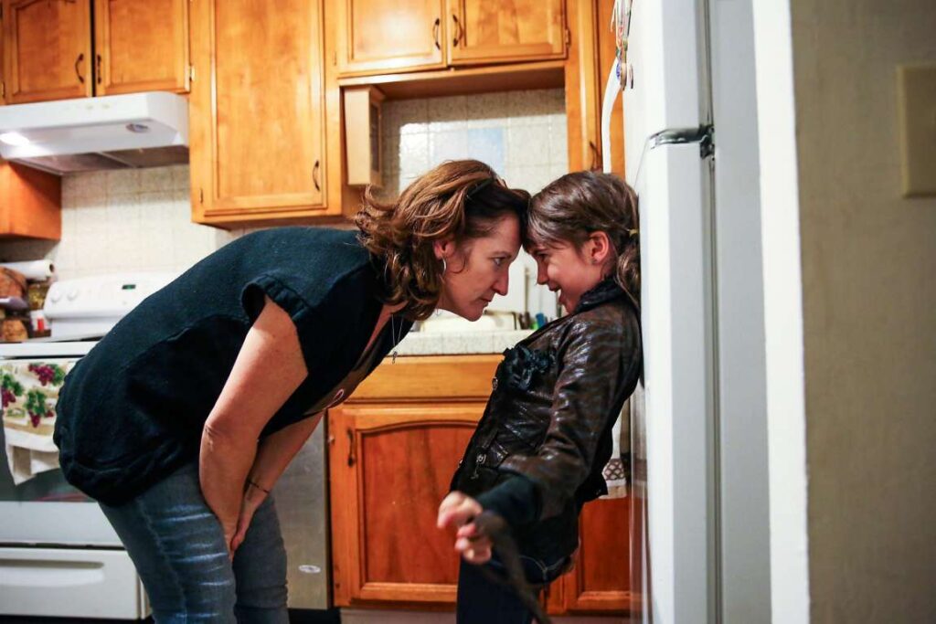 Mother and child playing in kitchen.
