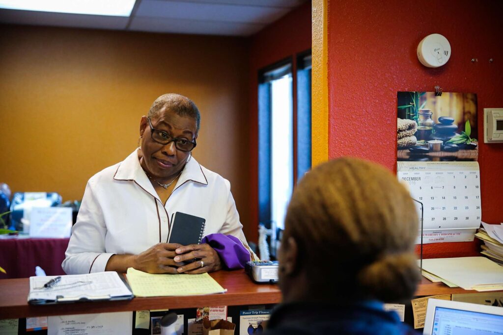Woman smiling at receptionist desk.