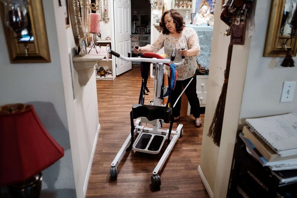 Woman using a walker in a hallway, illustrating support and mobility assistance.