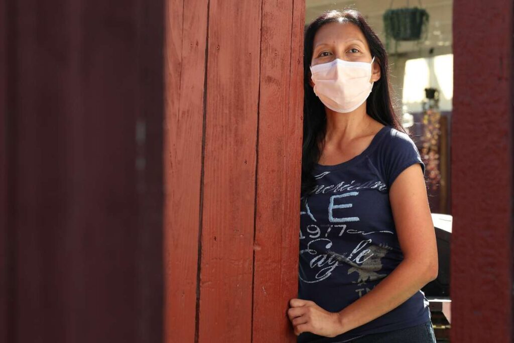 Woman in face mask standing in doorway.