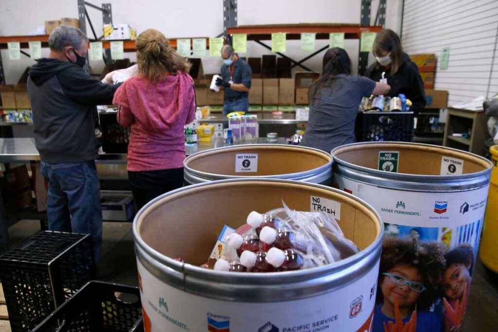 People sorting donations and canned food at a distribution site.