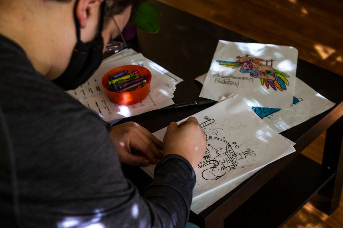 Close-up of young man drawing at a table.