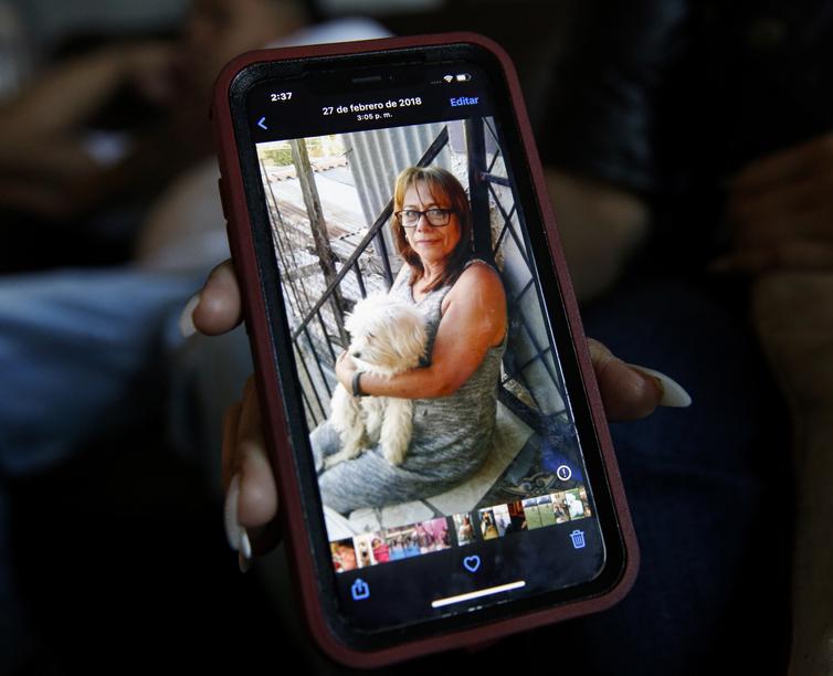 A smartphone displays a photo of a woman with a dog, smiling warmly—reflecting connection and closeness.