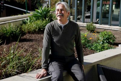 Man smiling in a garden—emphasizing nature and healing spaces.