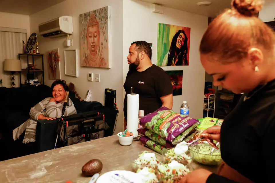 A family shares a lively moment in a kitchen around a table of snacks—emphasizing joy and connection at home.