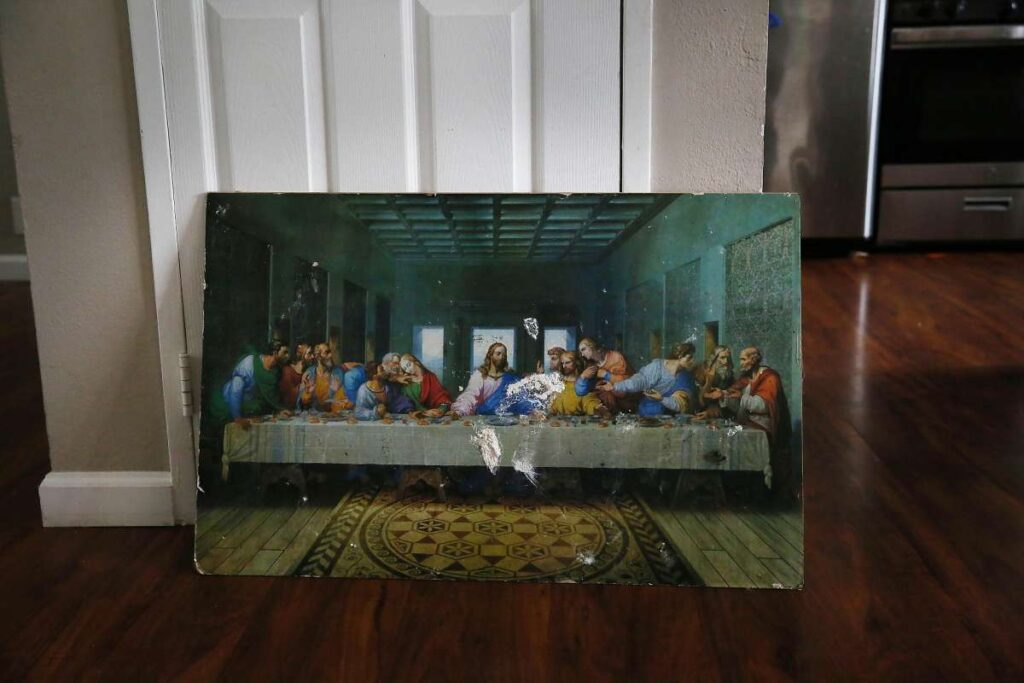 Portrait with a scene from the Last Supper displayed against a wall in a house.