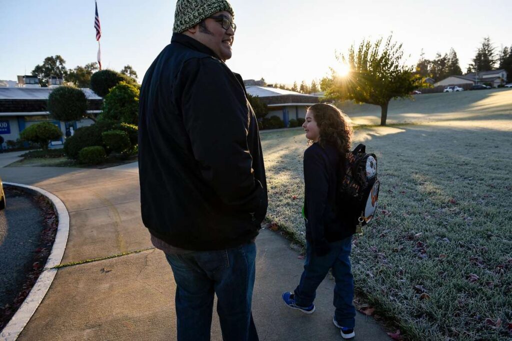 Father walks child to school in the morning.