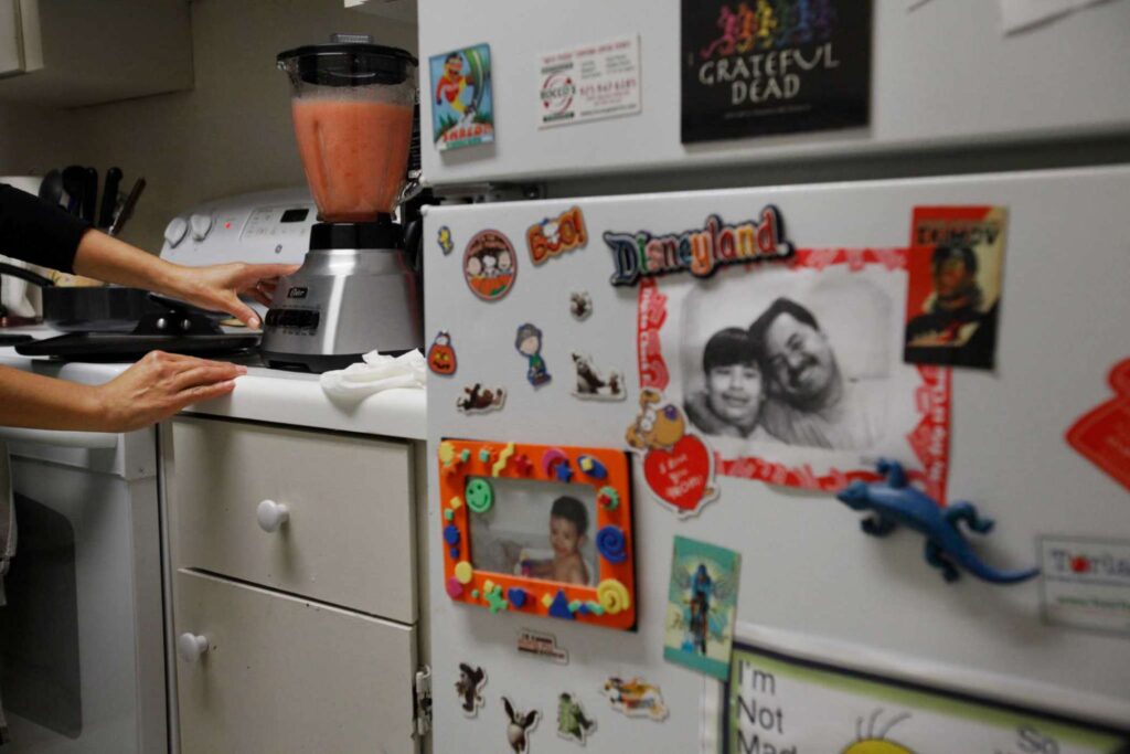 Refrigerator decorated with magnets and family photos.