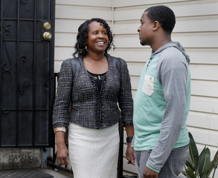 Mother and son chat on porch.
