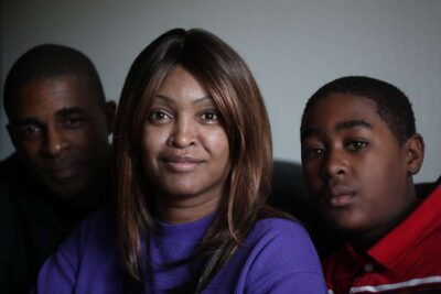 Family of three pose for close up photo.