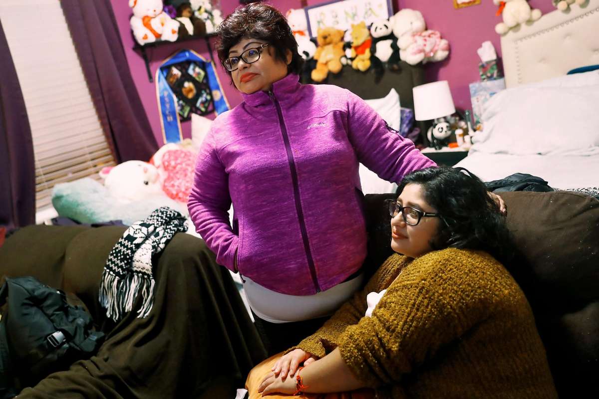 Woman standing proudly in her decorated bedroom.
