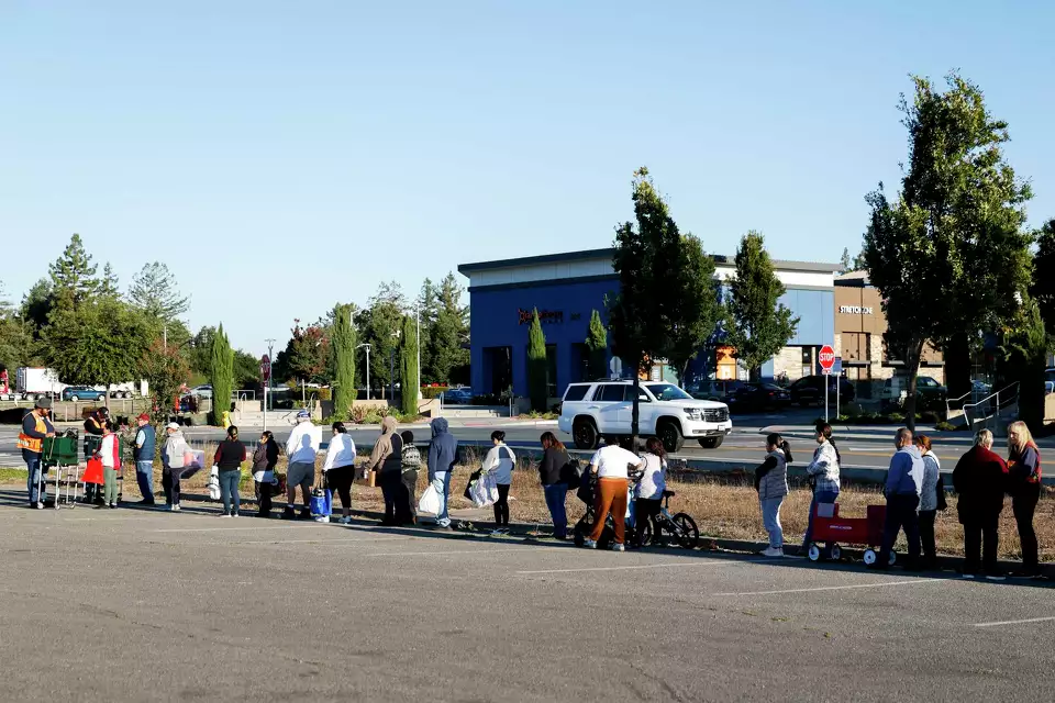 People line up at a food distribution event—demonstrating large-scale community support.