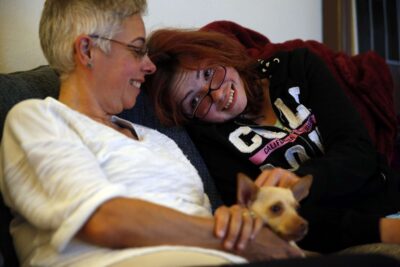 Family smiling on couch with small dog.