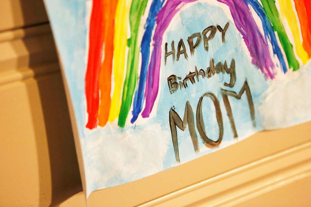 Child’s colorful handmade sign reading “Happy Birthday Mom.”