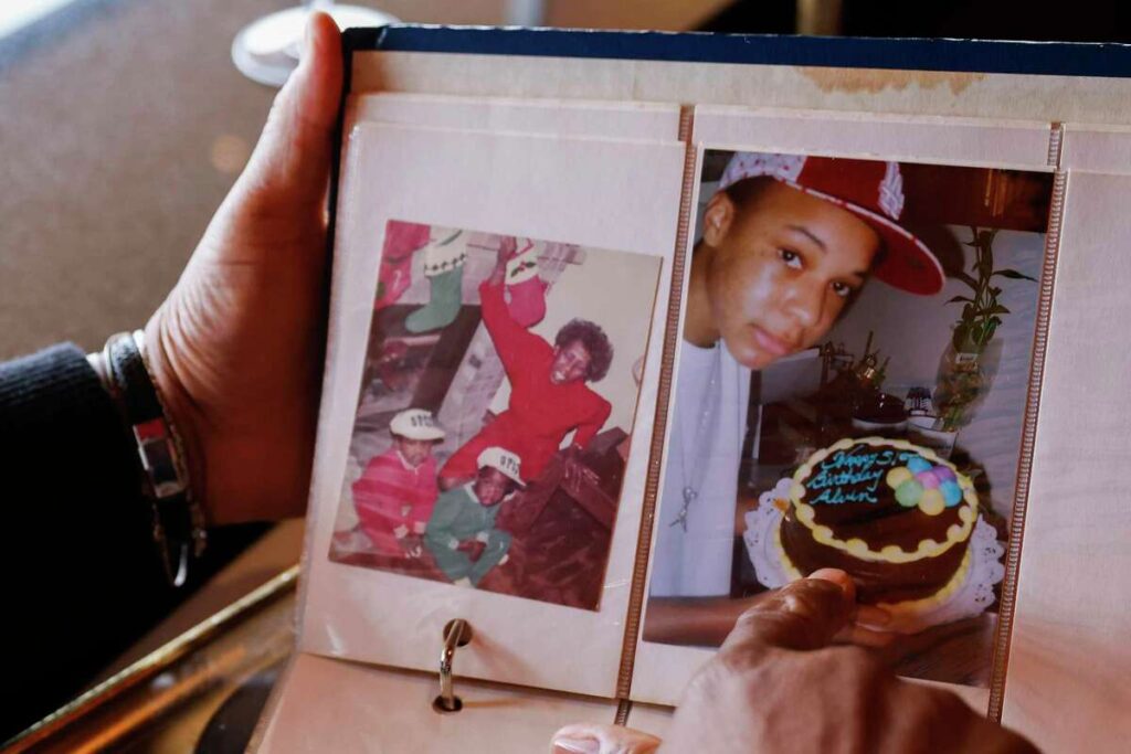 Close-up of a photo album showing a young man in various life stages—reflecting family pride.