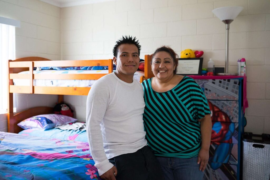 Couple poses in children's bedroom.