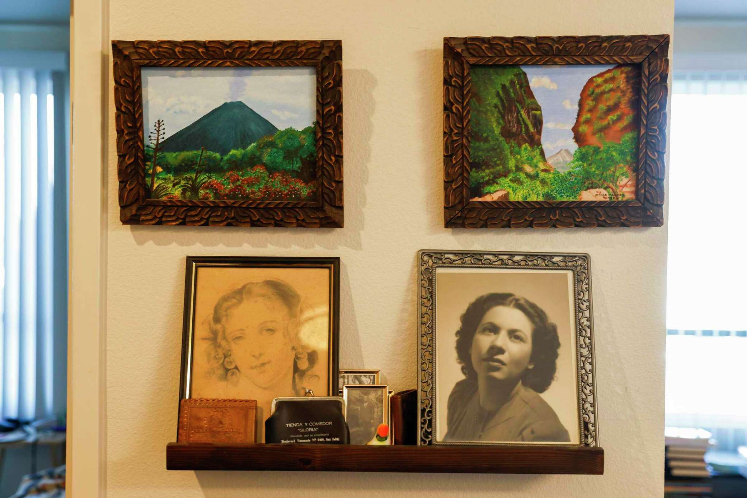 A wall filled with framed photos, including a black-and-white portrait of a woman—honoring personal and cultural history.