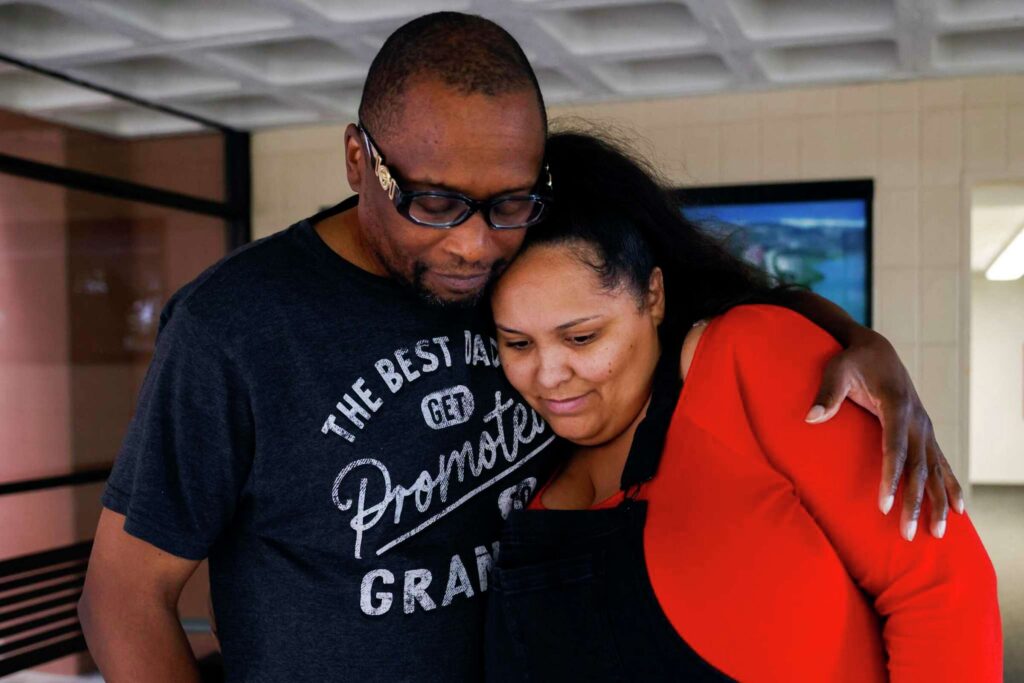 A couple embraces with emotional intensity—expressing solidarity and support.