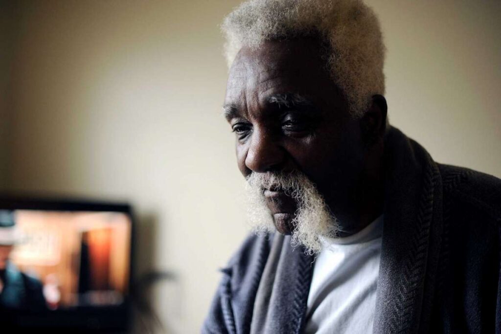 Elderly man sitting looking content for a photo.