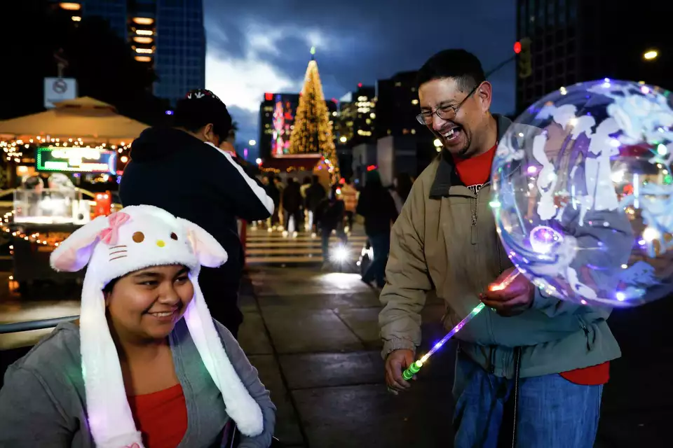 A family enjoys a night out at a fair, surrounded by lights and holding balloons—capturing joy and togetherness.