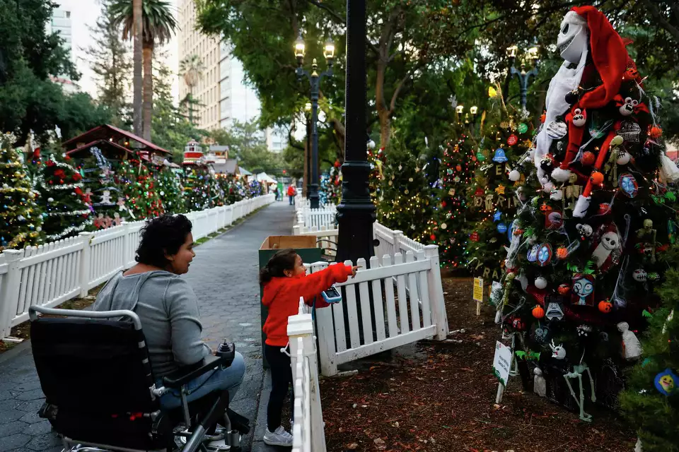 Two children in front of a decorated holiday fence—celebrating tradition and community spirit.
