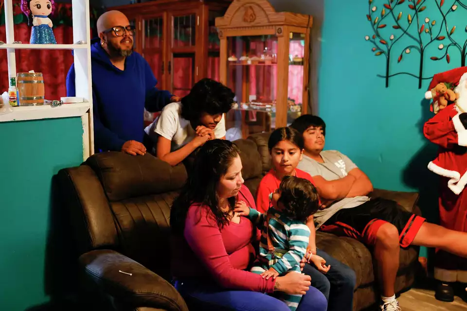 A family gathers in a holiday decorated living room—enjoying connection during festive moments.