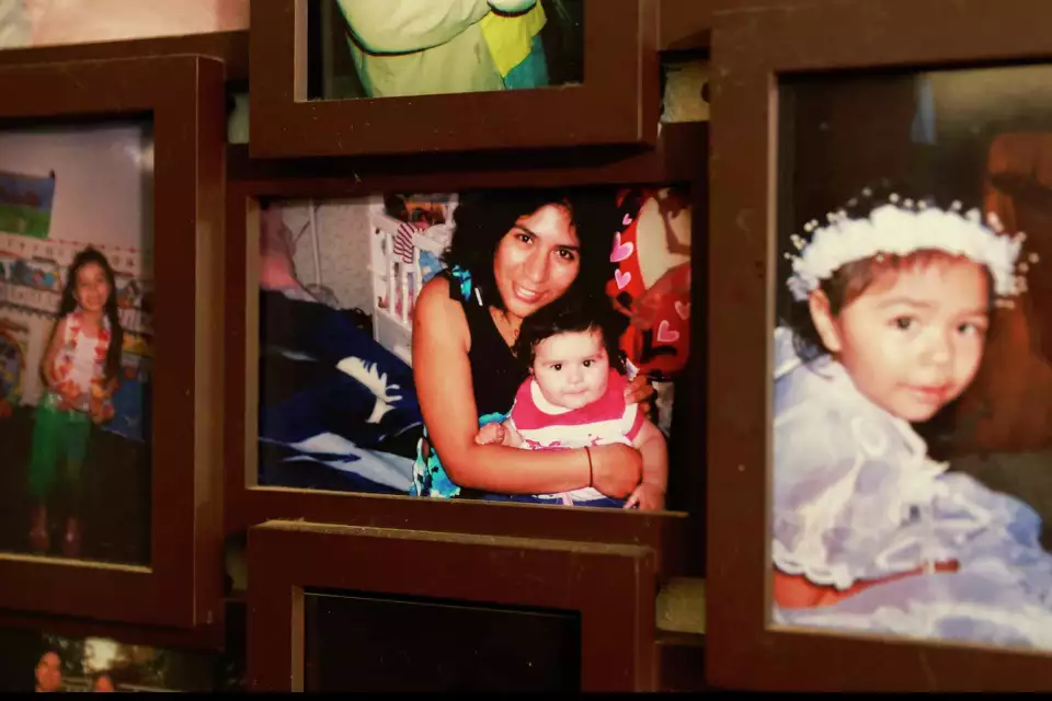 Grouping of framed photos featuring a picture of woman and child smiling.