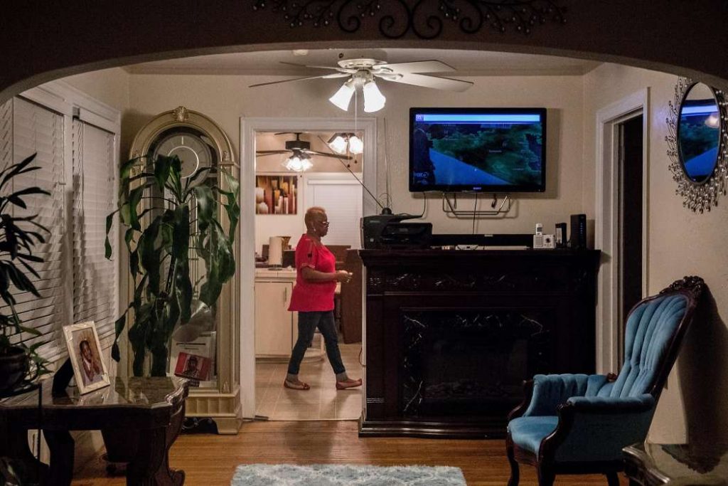 Woman stands in apartment living room.