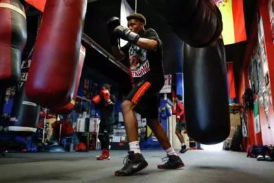 Young people train in a boxing gym, focused and in motion—highlighting discipline and empowerment.
