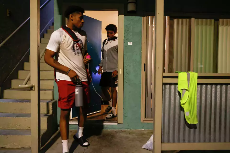 Two brother leaving modest apartment—illustrating family and home.