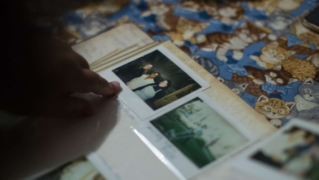 Close-up of someone placing a printed photo into a photo album.