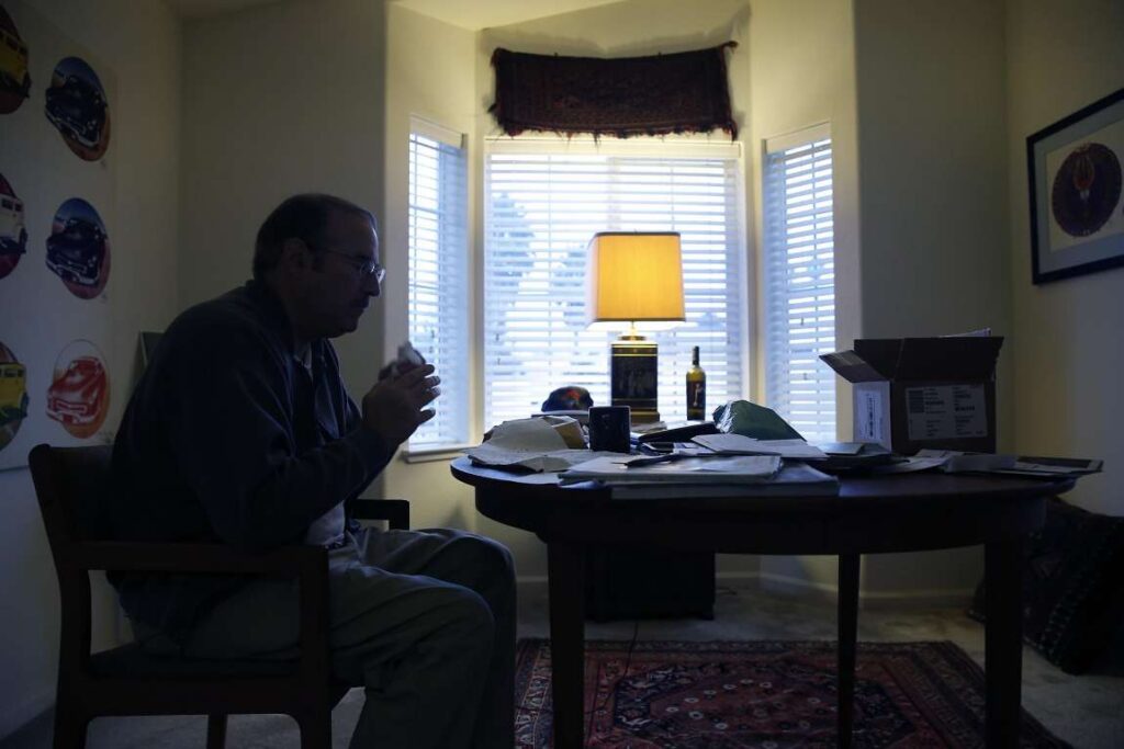 Man eating a meal at table in dimly lit room.