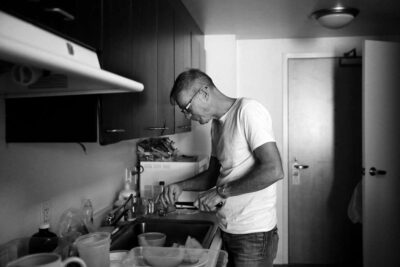 Man preparing food in a small kitchen.