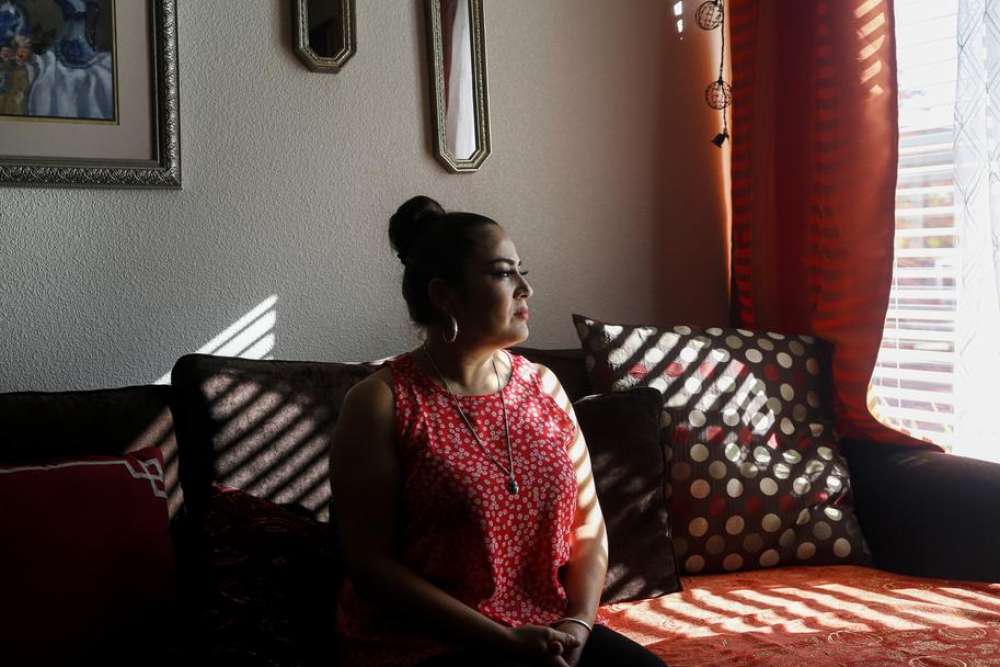 A woman sits in a sunlit room looking out the window—suggesting contemplation, peace, and solitude.