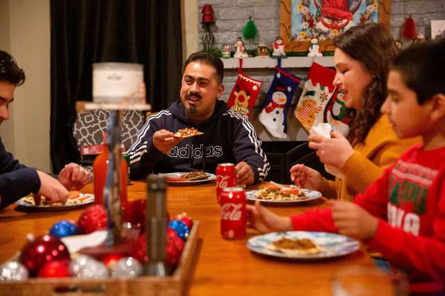 Family sharing a holiday dinner together at a decorated table.