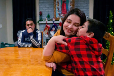 Woman embracing child on dining table.
