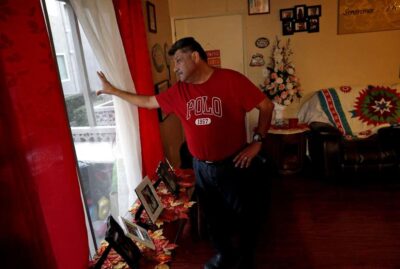 Man gazes outside living room window.