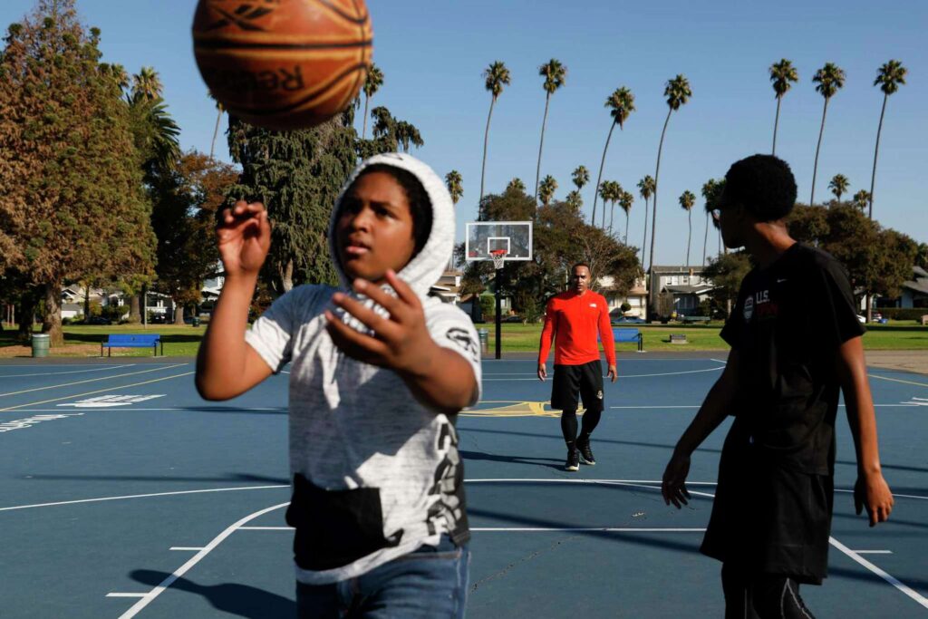 A child prepares to shoot a basketball, eyes focused—highlighting confidence and physical activity.