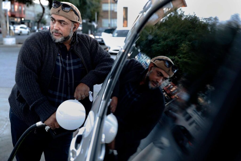 Man filling car with gas at gas station.