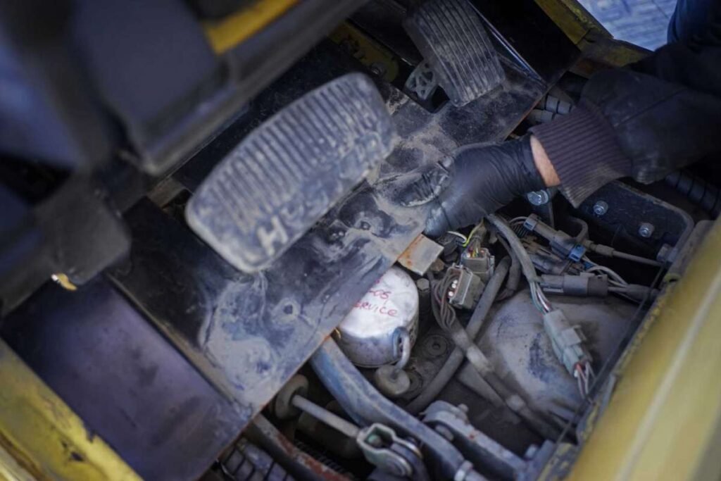 Close up of hand doing maintenance on a forklift.