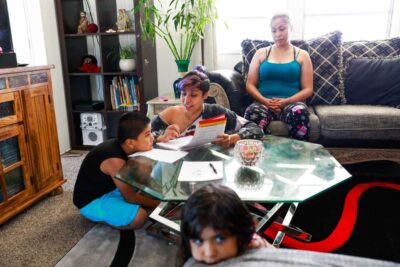 Family gathered around a glass coffee table talking and eating.