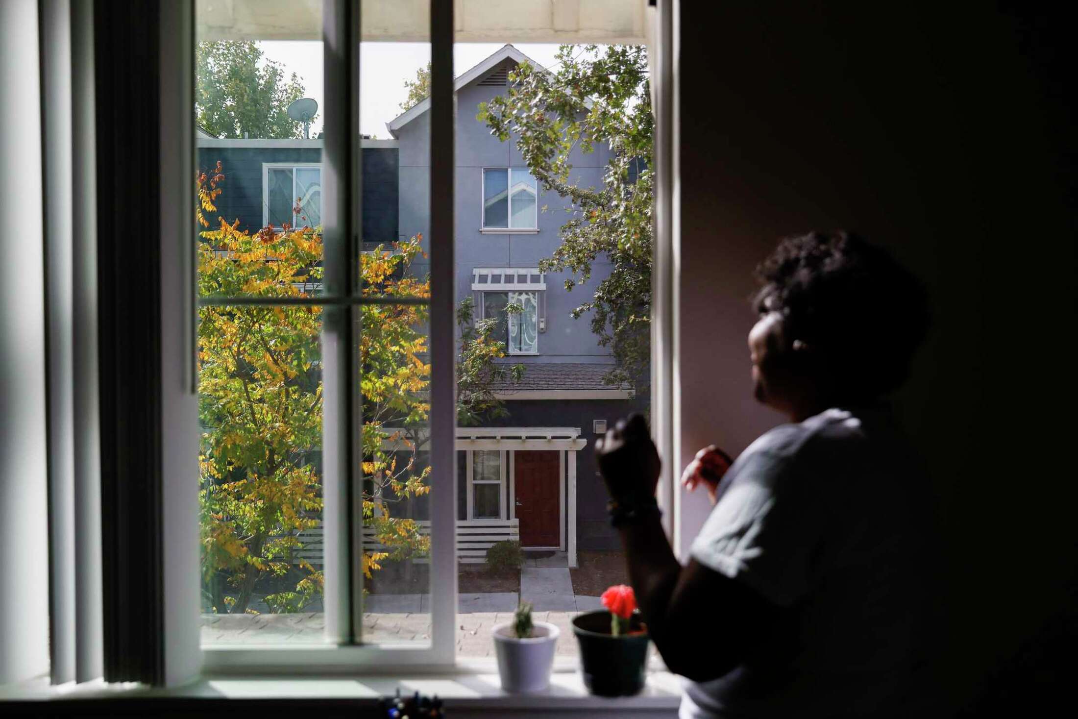 A woman gazes out a sunny window—conveying peace and reflection.