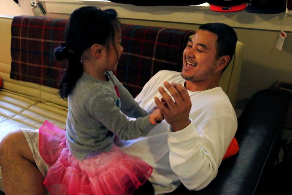 A young girl in a pink tutu dances joyfully with a father—capturing laughter, bonding, and play.