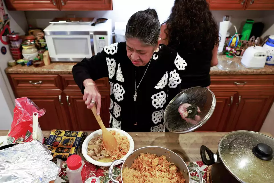 Two women prepare a meal together in a cozy kitchen, sharing a moment of joy while cooking—highlighting connection and tradition.
