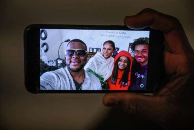 A phone shows a smiling selfie of four people—highlighting connection in a digital age.