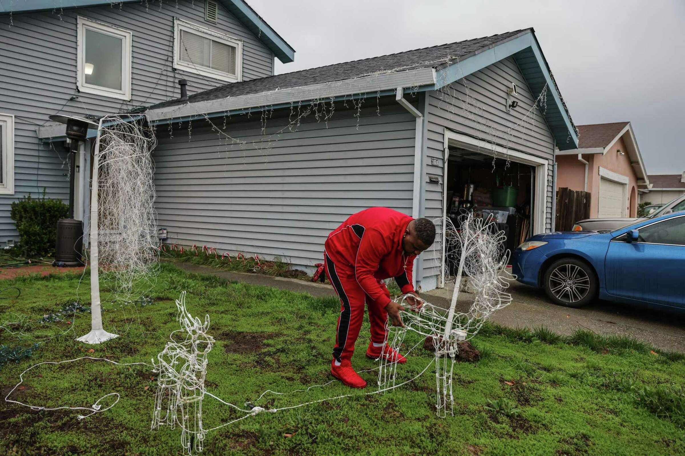 A person bends over to tend a yard in front of a small home—symbolizing care and maintenance.