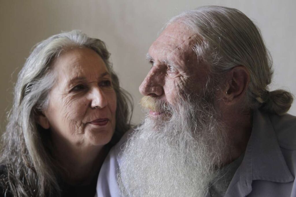 Elderly couple gazing at each other supportingly.