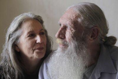 Elderly couple gazing at each other supportingly.