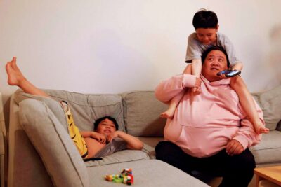 Two children play with parent on couch—conveying play and bonding.